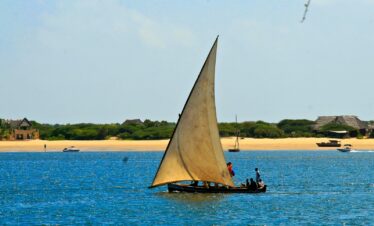 a sailboat with two people on it in the water