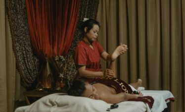 A woman receives a therapeutic massage from a professional masseuse in a calming spa environment.